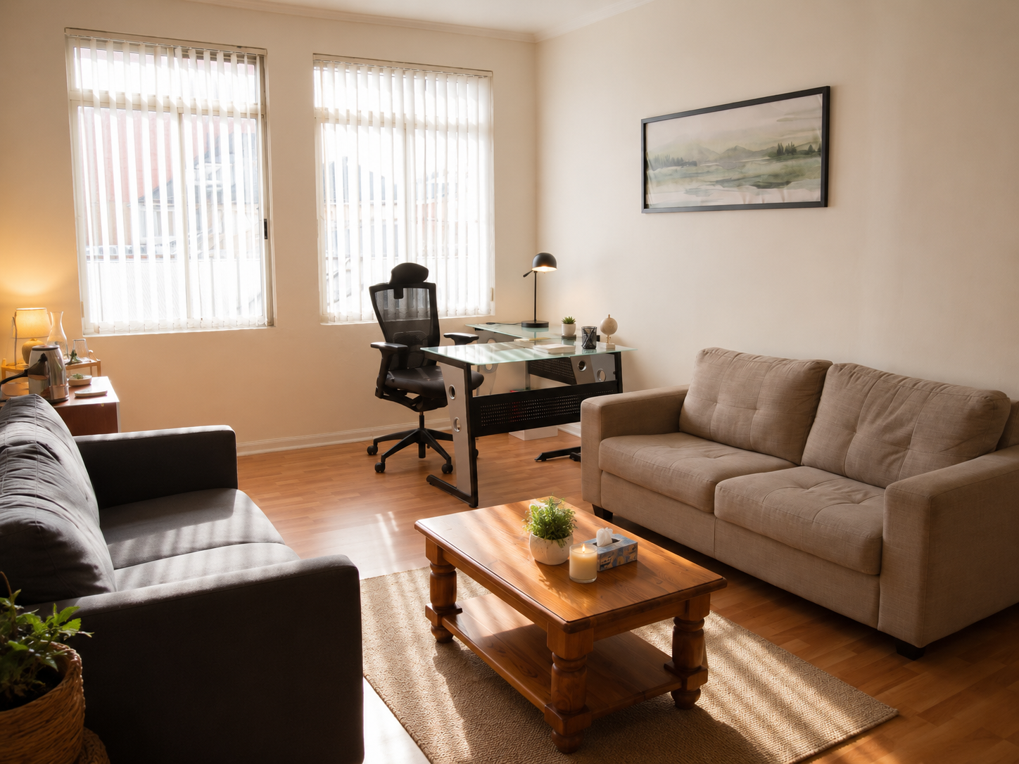 Sala de sesiones con escritorio, sofás y luz natural de ventana